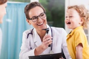 רופא עורכת בדיקה לילד המטופל מכבי שירותי בריאות