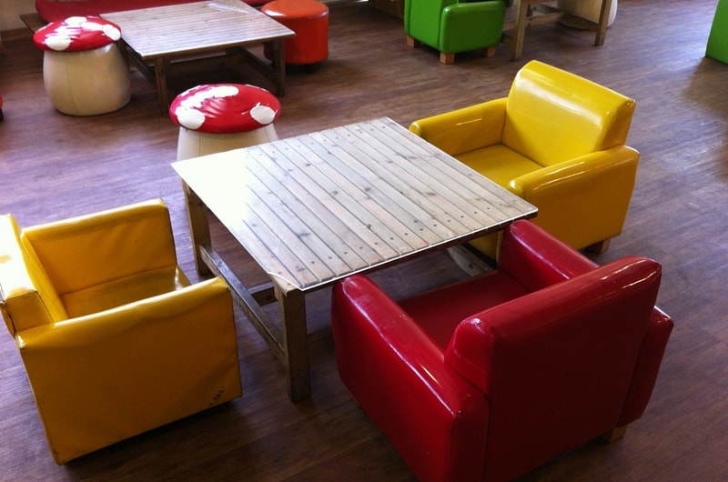 שולחן עץ וכורסאות בצבעי צהוב אדום