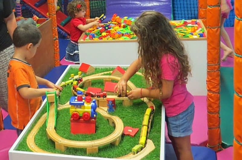 ילדים משחקים ובונים מסילת עץ לרכבת